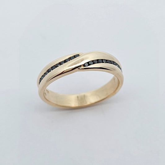 Yellow gold wedding ring with sleek crossover design set with black diamonds.