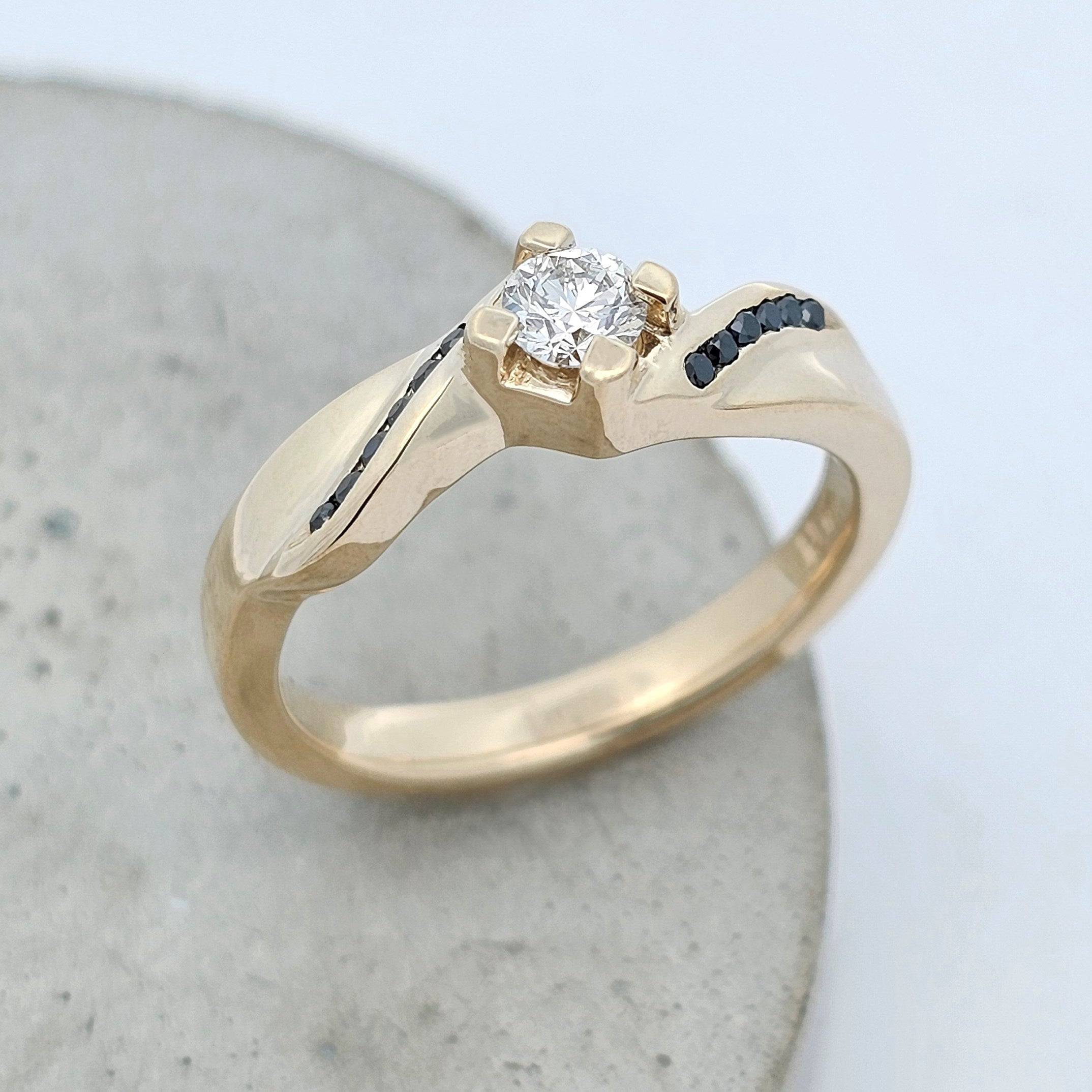 yellow gold claw-set diamond engagement ring with black diamond shoulder accent stones