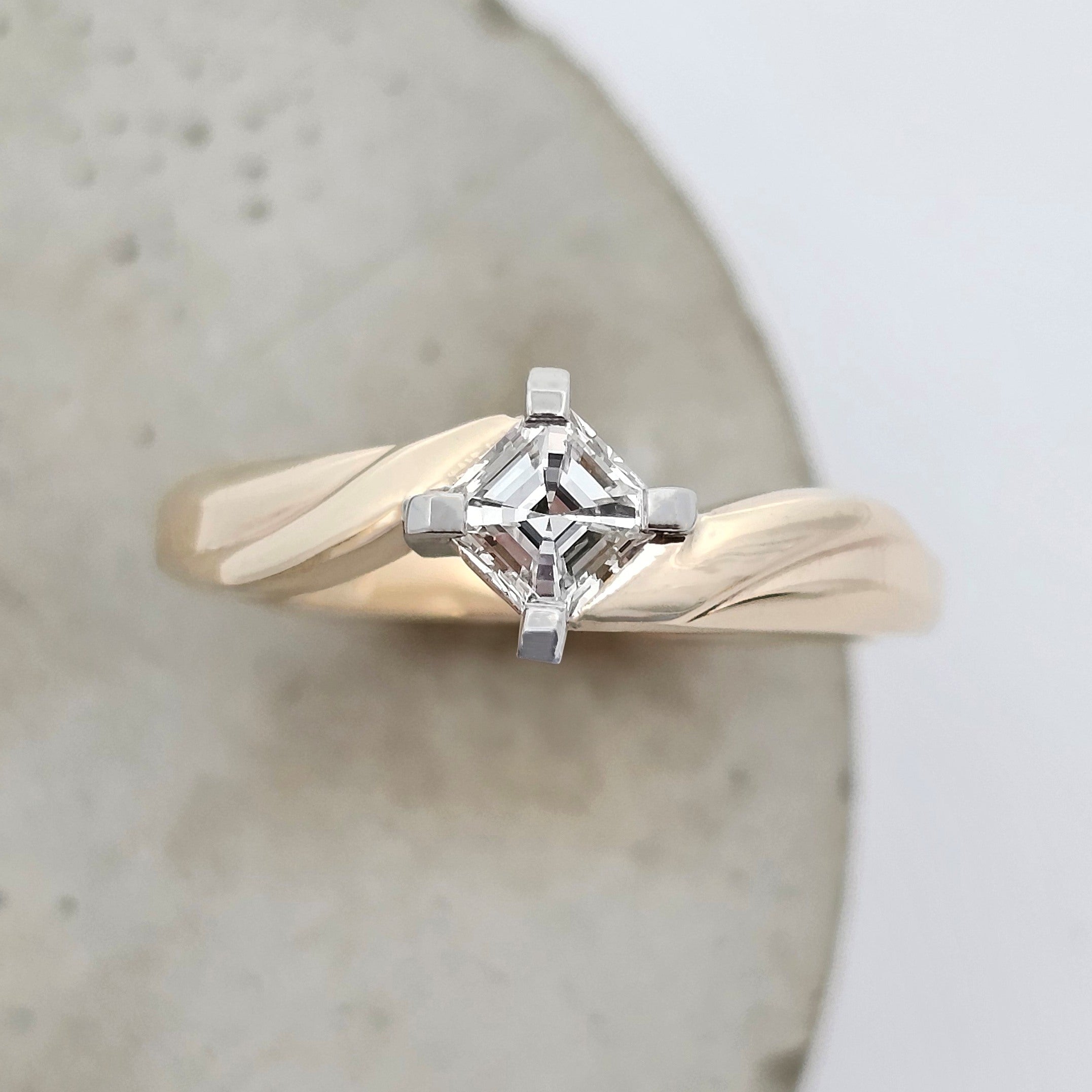 symmetrical yellow gold ring set with asscher cut diamond