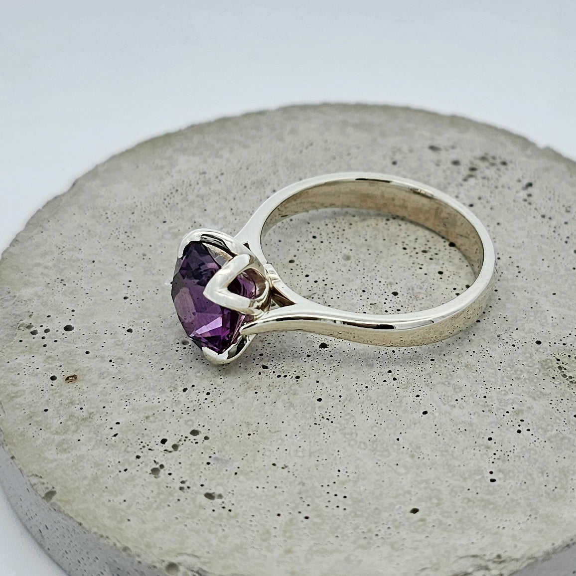 9ct white gold ladies coloured stone ring with a large square dark purple amethyst in a floral shaped claw setting.