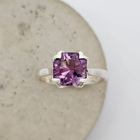 9ct white gold ladies coloured stone ring with a large square dark purple amethyst in a floral shaped claw setting.