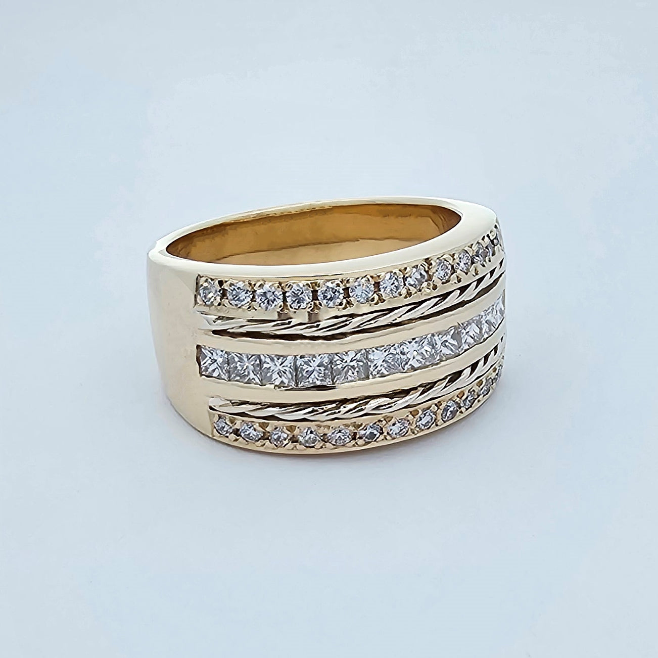 9ct yellow and white gold wide ladies dress ring, featuring two rows of bead set round white diamonds, one row of channel set princess cut diamonds and two rows of twisted round gold wire.