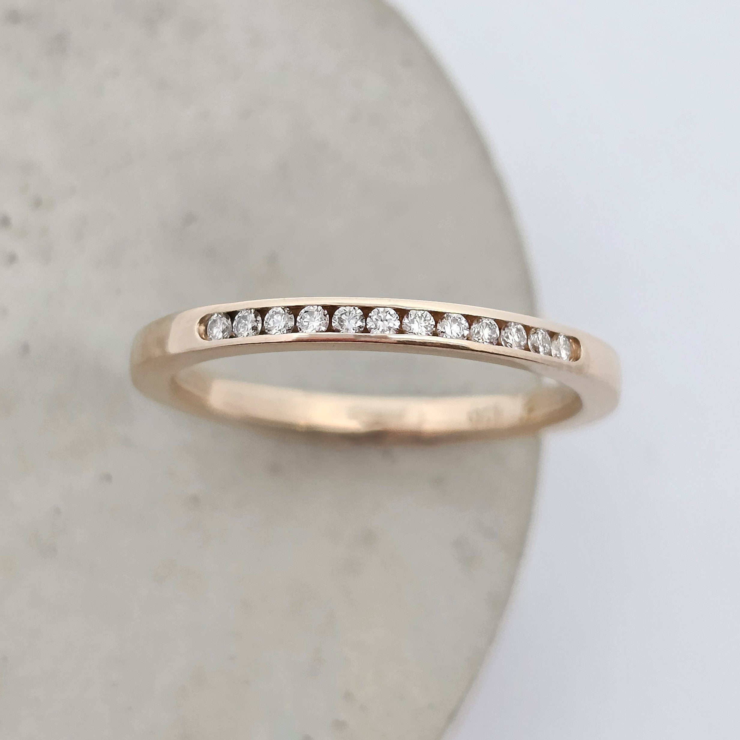 Channel-set diamond wedding band in yellow gold with a fine row of stones.