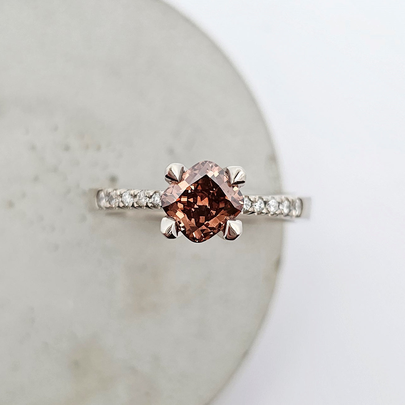9ct white gold ladies engagement ring featuring a cushion cut deep brown Argyle Champagne diamond and bright white diamonds bead set into the shoulder.
