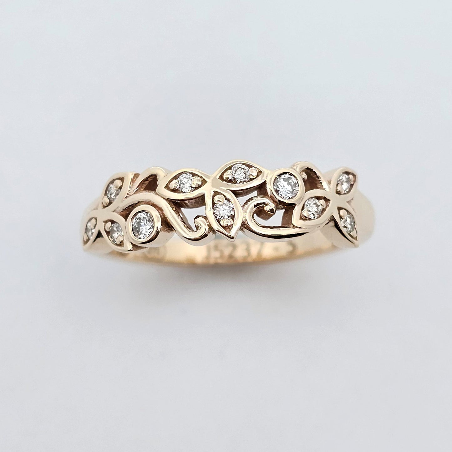 Yellow gold diamond ring with a petal-inspired design, featuring intricate openwork and white diamonds set in each petal for a delicate, nature-inspired look.