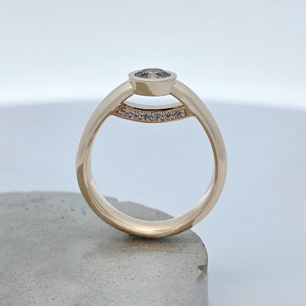 Yellow gold diamond ring featuring a bezel-set Argyle chocolate diamond with a hidden row of white diamonds beneath the centre stone.