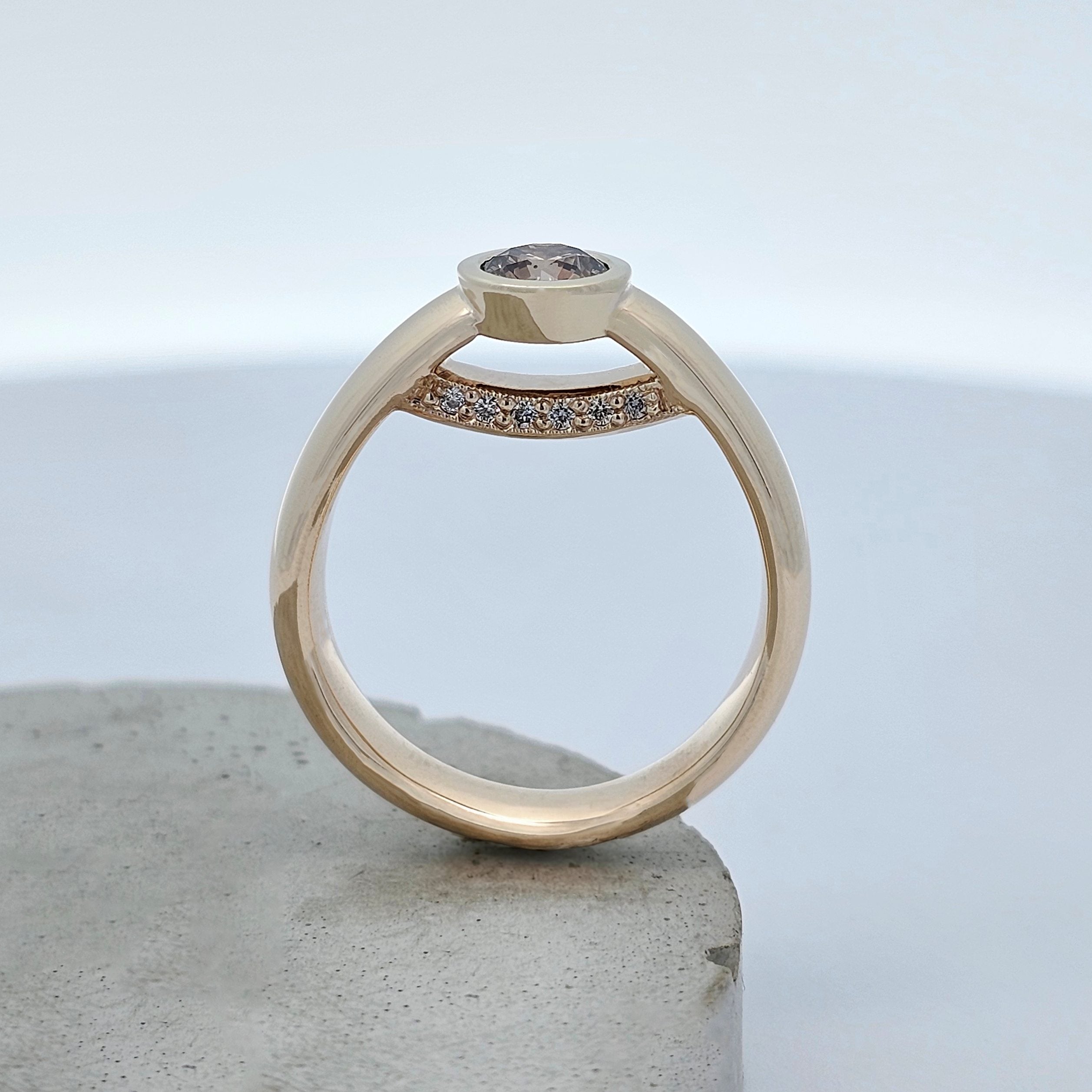Yellow gold diamond ring featuring a bezel-set Argyle chocolate diamond with a hidden row of white diamonds beneath the centre stone.