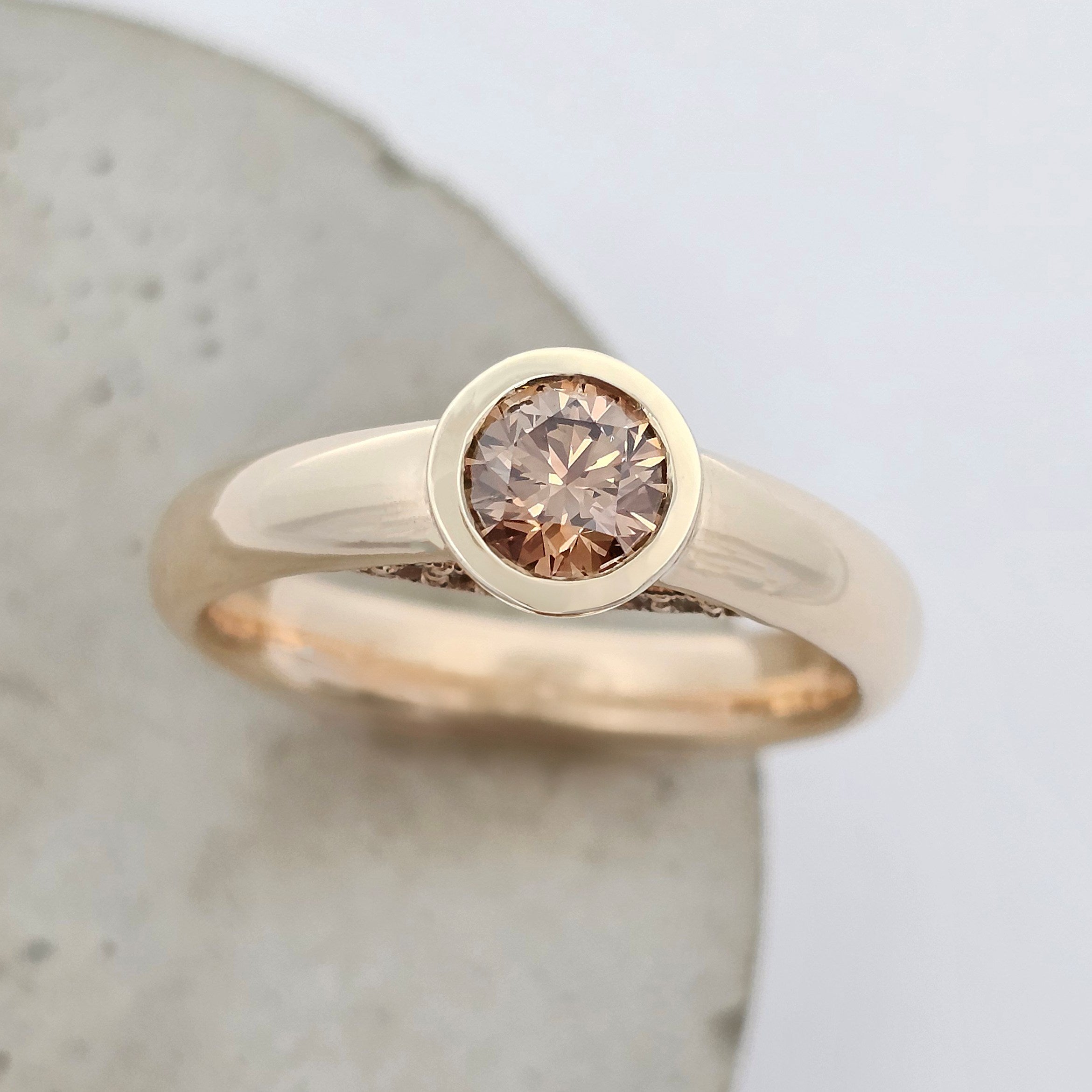 Yellow gold diamond ring featuring a bezel-set Argyle chocolate diamond.