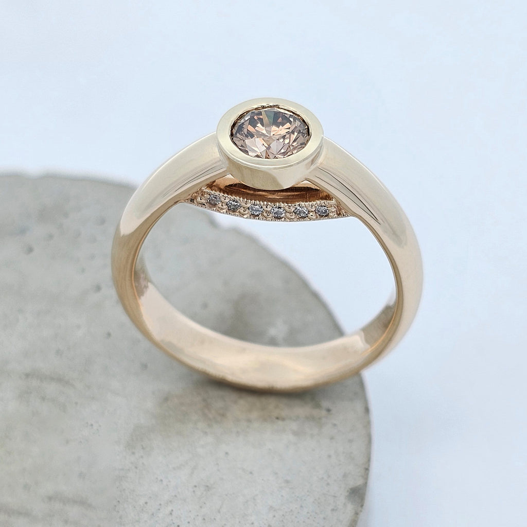 Yellow gold diamond ring featuring a bezel-set Argyle chocolate diamond with a hidden row of white diamonds beneath the centre stone.