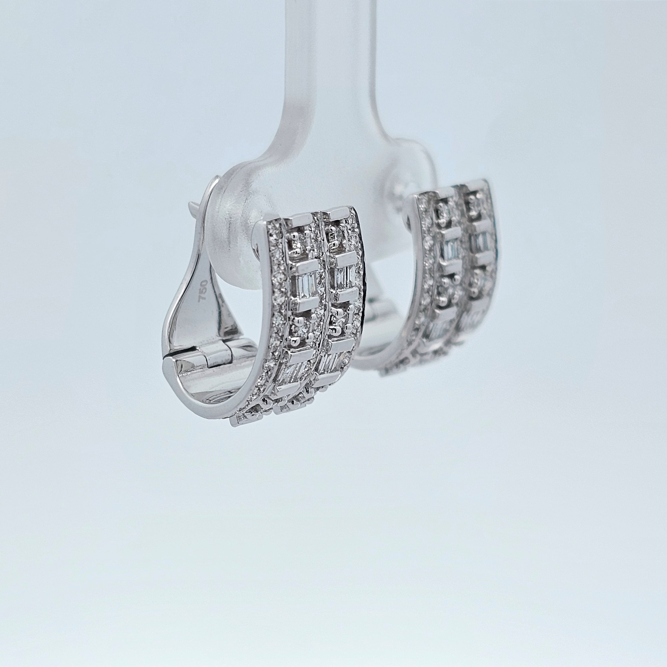 White gold huggie earrings set with rows of baguette and round diamonds in a bold, modern design.