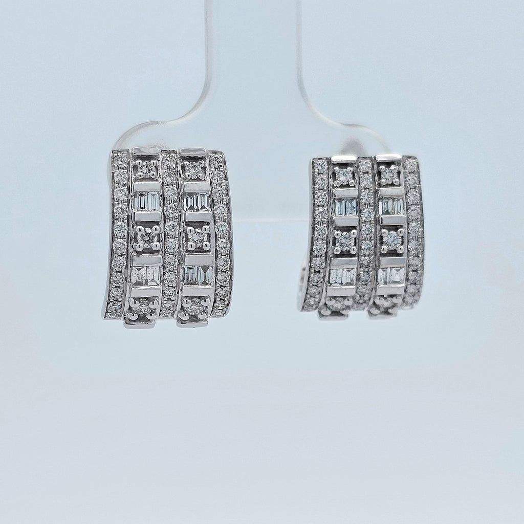 White gold huggie earrings set with rows of baguette and round diamonds in a bold, modern design.