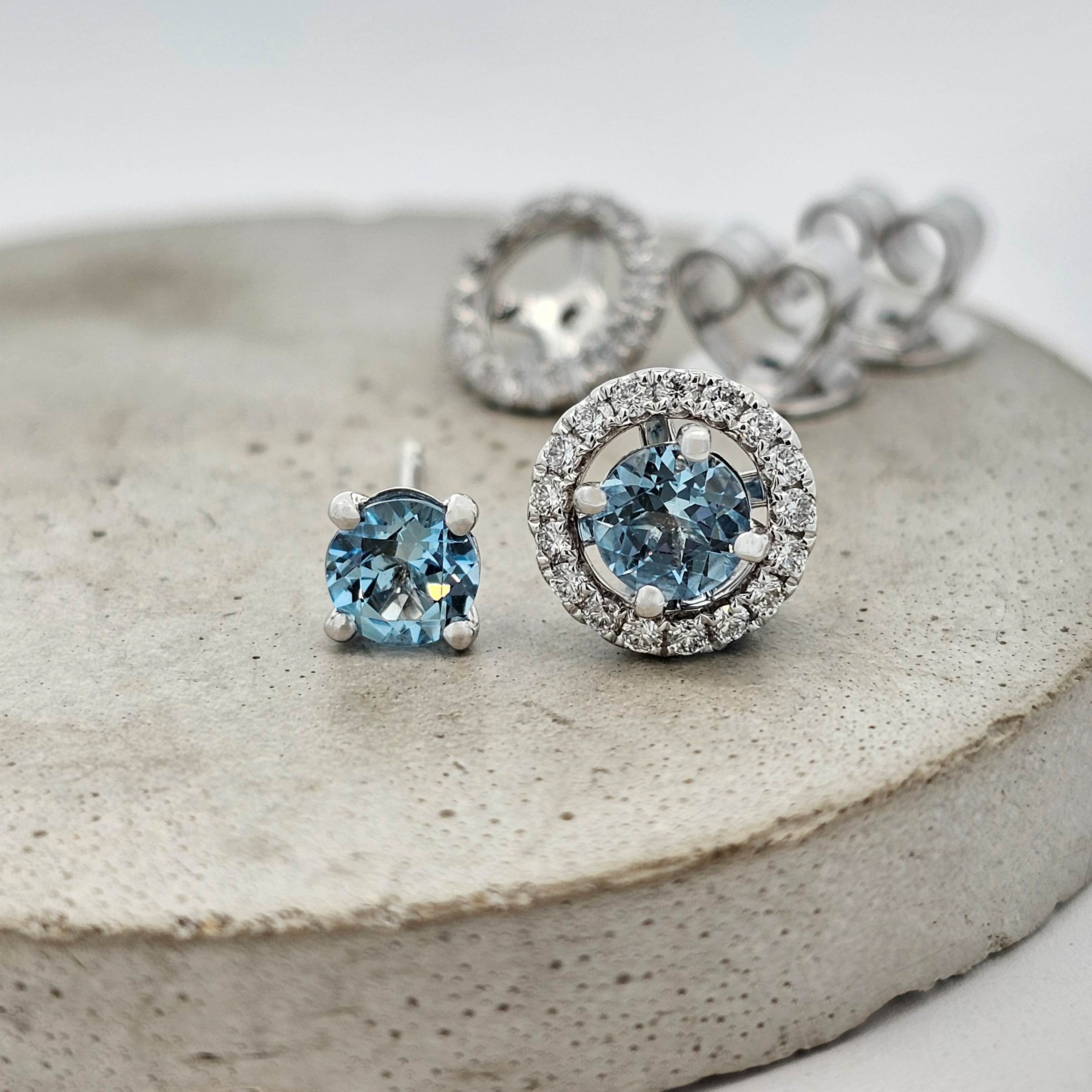 Aquamarine stud earrings in white gold, shown with and without removable diamond halo jackets for versatile wear.