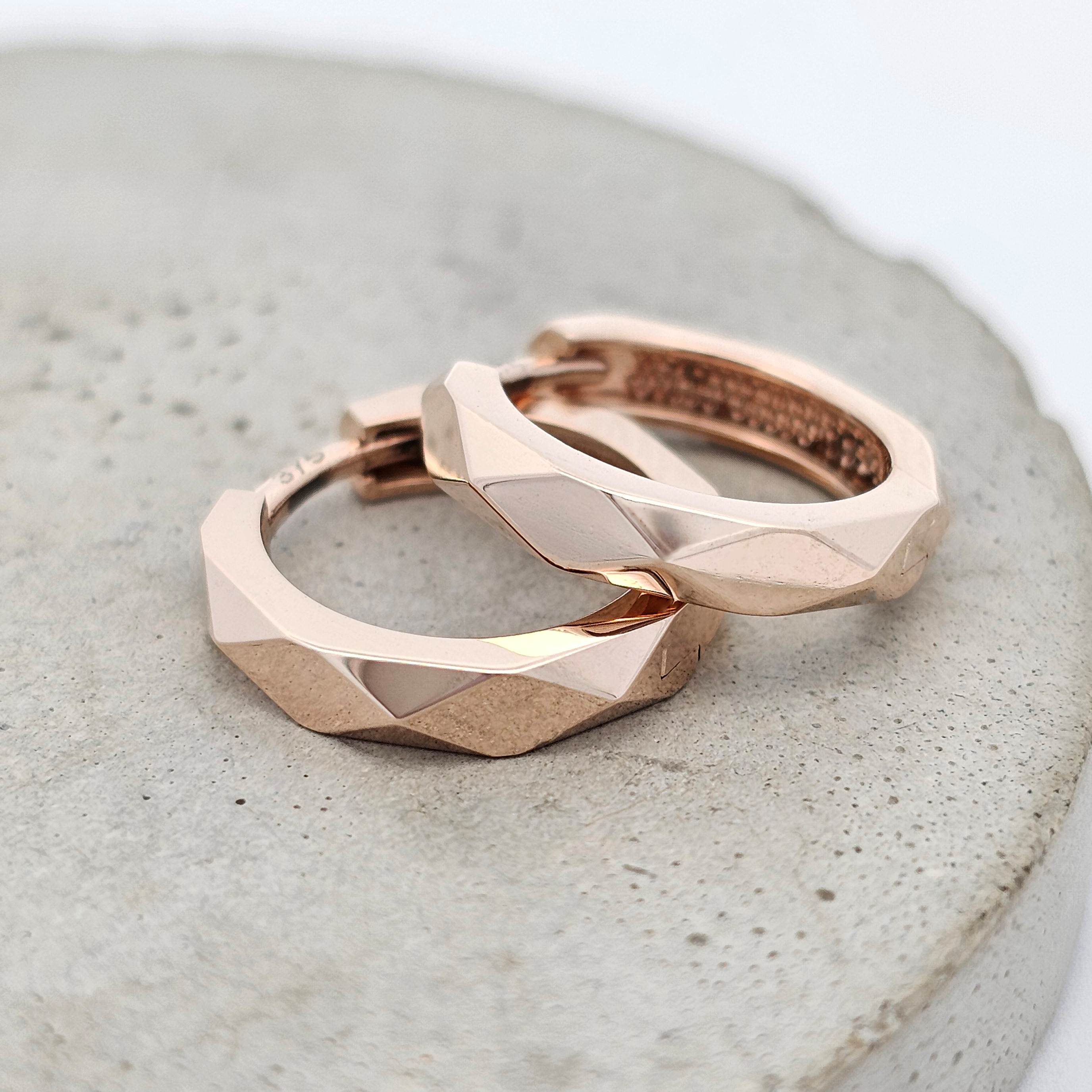 Pair of rose gold geometric huggie hoop earrings with faceted edges