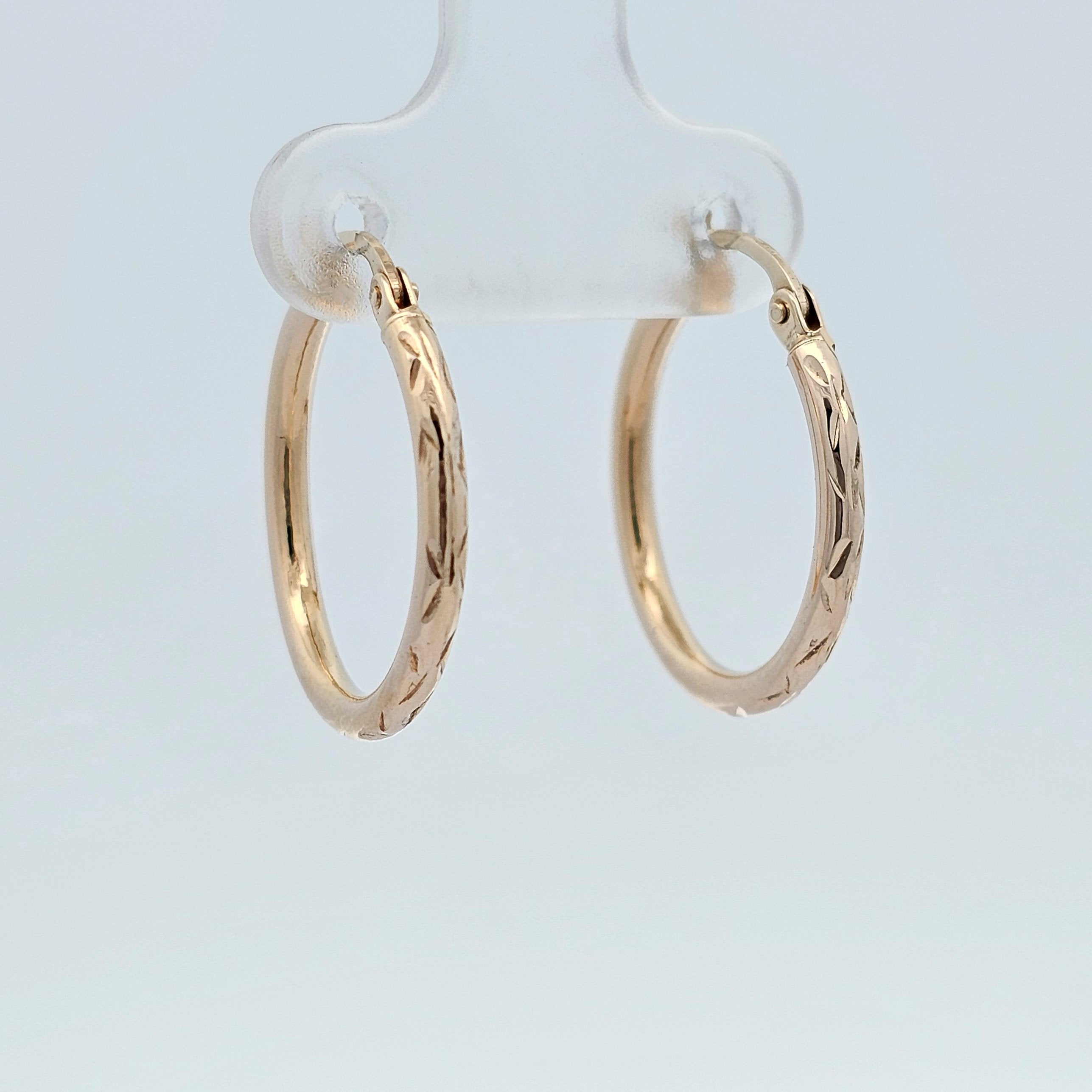 Yellow gold hoop earrings with engraved detailing.