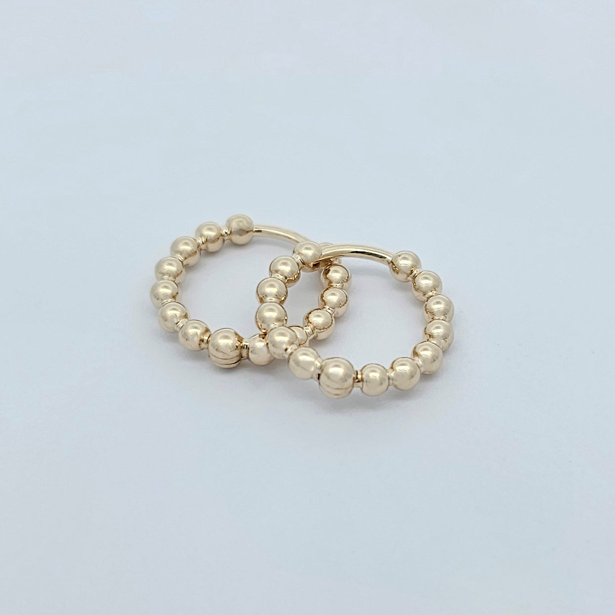 Pair of gold beaded hoop earrings with polished spherical details