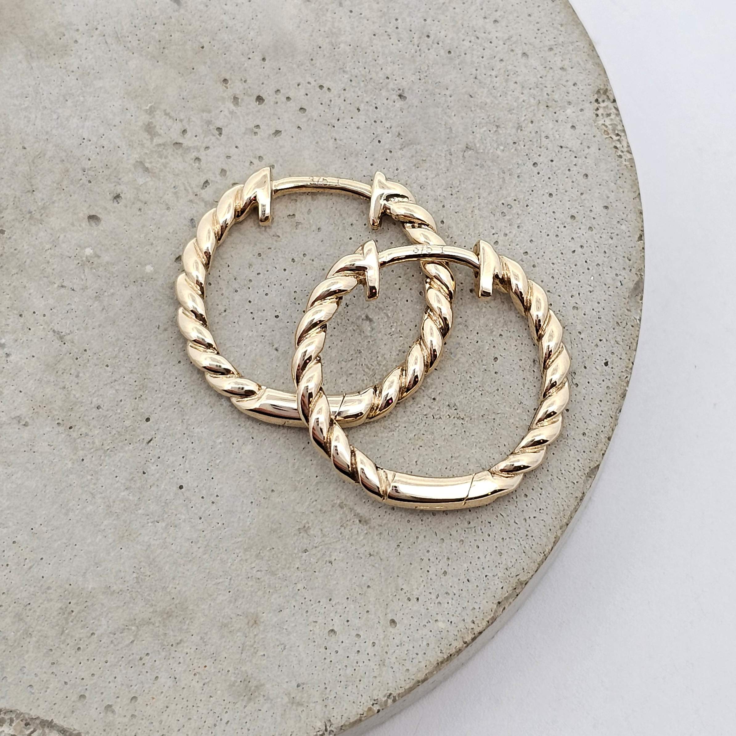 Twisted yellow gold hoop huggie  earrings with rope-style detailing.