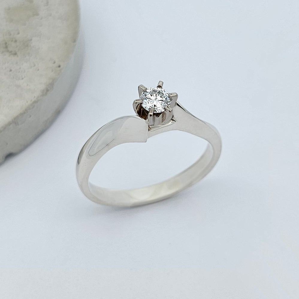 Classic 9ct white gold ladies solitaire engagement ring, with a sparkling round white diamond, claw set between the sweeping curves of knife edge shoulders.