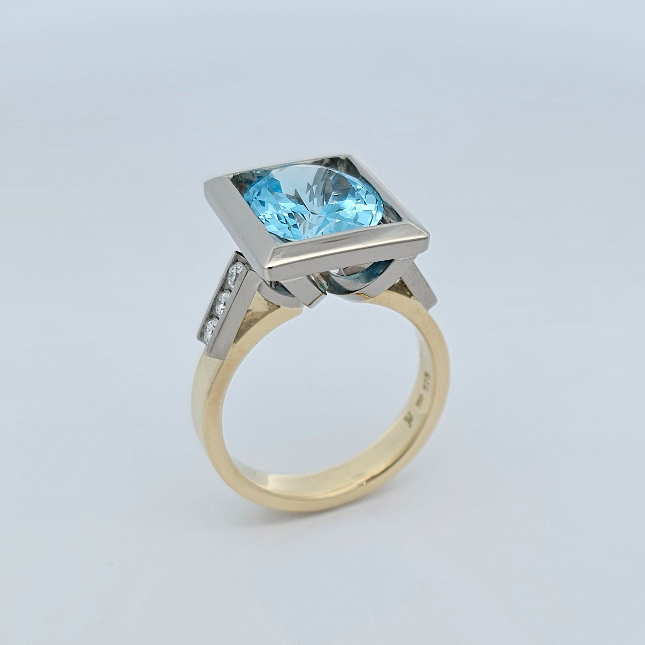 18ct yellow and 9ct white gold ladies dress ring with a large oval aquamarine set in a white gold setting with round brilliant white diamonds channel set in each shoulder.