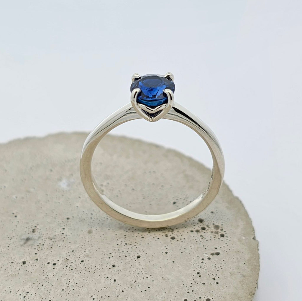 9ct white gold ladies engagement ring with a four claw set fine blue oval sapphire.