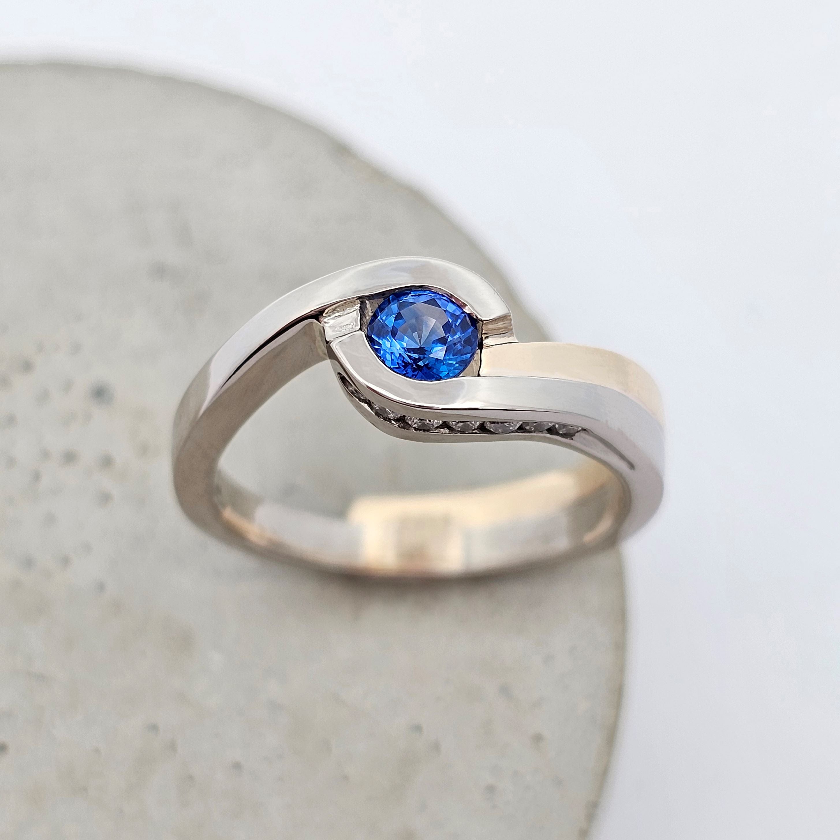 sapphire ring; sapphire band; sapphire engagement ring; sapphire dress ring; sapphire and diamond ring; sapphire crossover ring; September birthstone ring; 45th wedding anniversary gift; 45th wedding anniversary ring; wedding anniversary ring; white gold sapphire ring; white and yellow gold sapphire ring; two tone sapphire ring; one-of-a-kind sapphire ring; round sapphire ring; blue sapphire ring