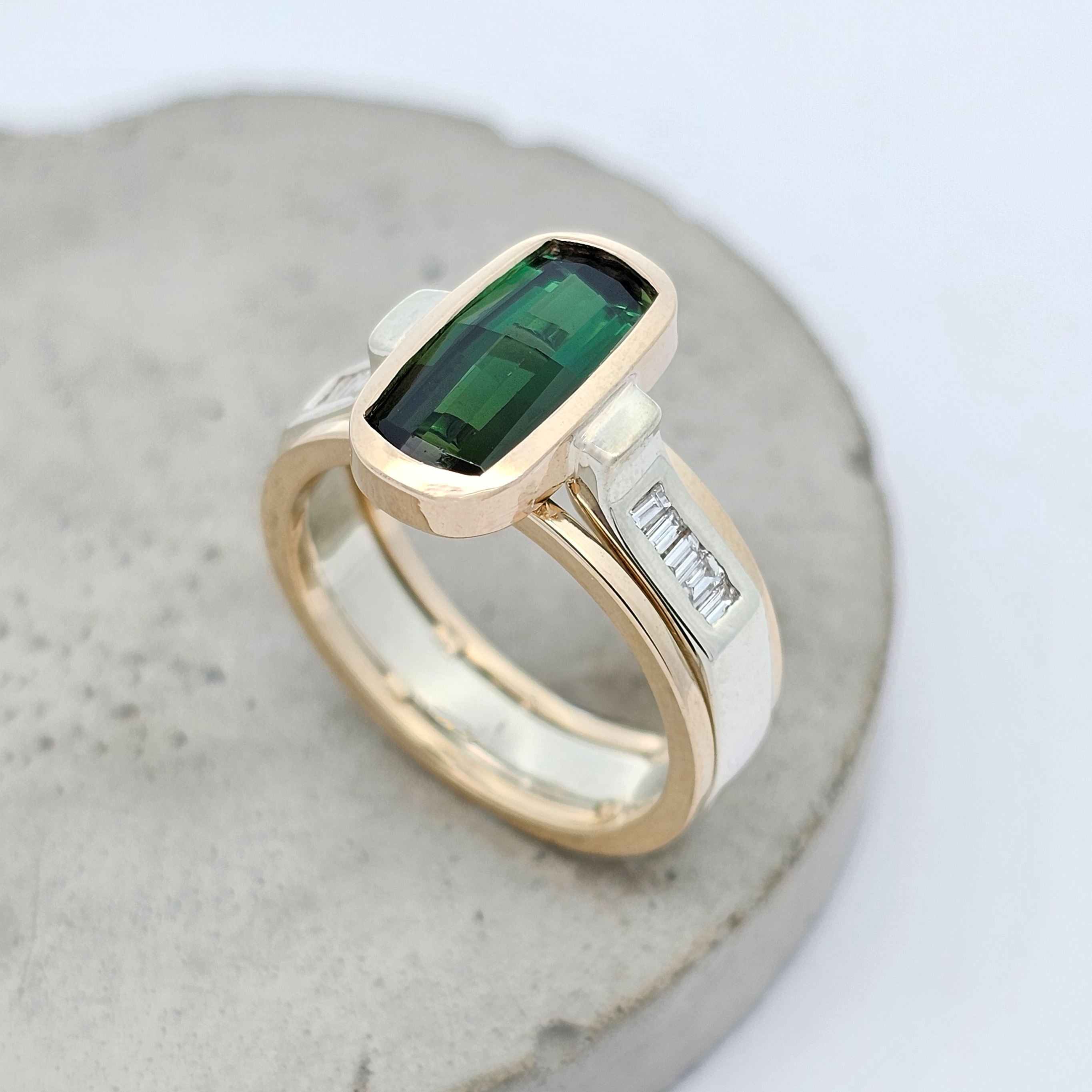 Elongated green tourmaline ring with baguette diamond accents in a contemporary yellow and white gold design.
