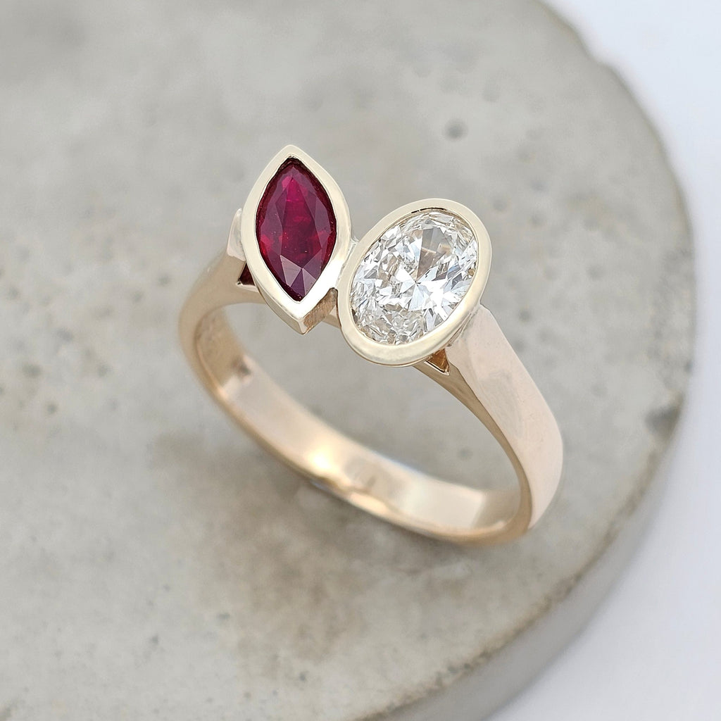 Ruby Remix ruby and diamond Toi et Moi ring with marquise ruby and oval diamond rub-set in yellow gold.