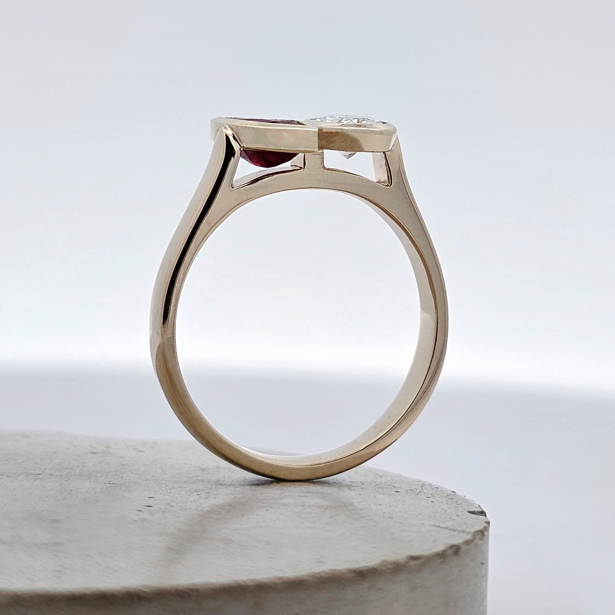 Ruby Remix ruby and diamond Toi et Moi ring with marquise ruby and oval diamond rub-set in yellow gold. Side view.