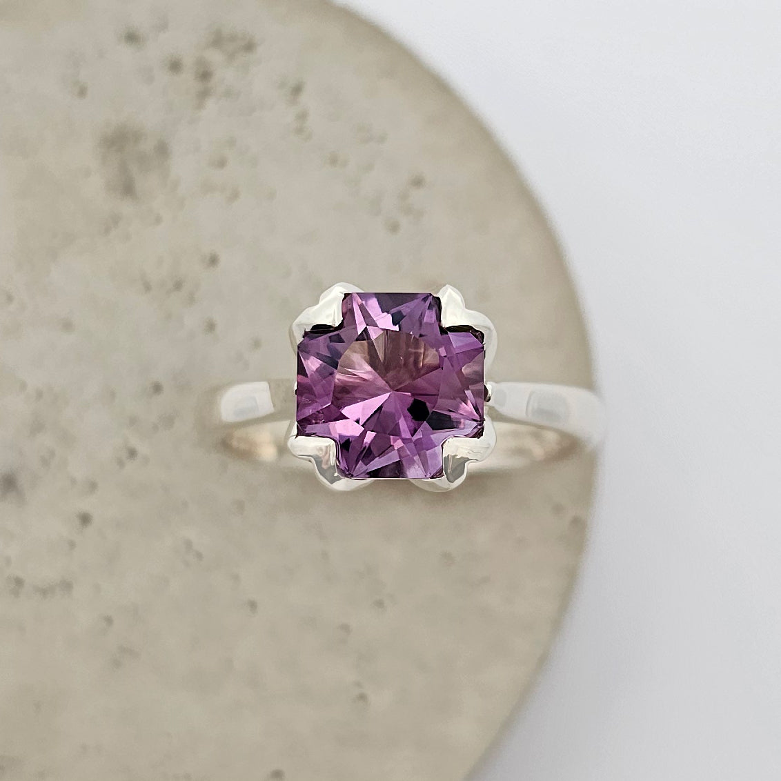 9ct white gold ladies coloured stone ring with a large square dark purple amethyst in a floral shaped claw setting.