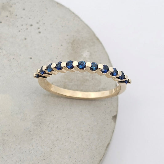 9ct yellow gold ladies straight wedding band with claw set round fine blue sapphires.