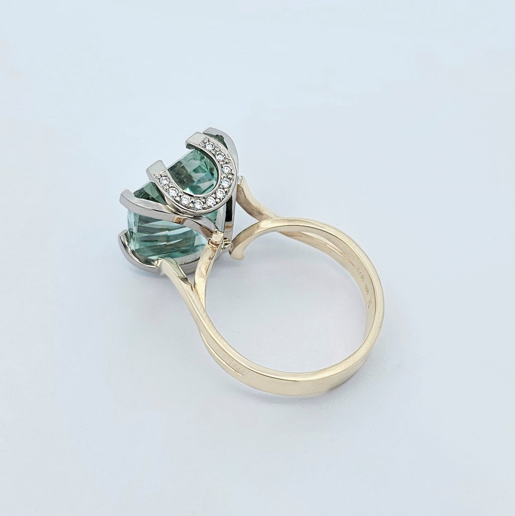 9ct yellow and white gold ladies dress ring featuring an extra large checker board cut aquamarine with round white diamonds set into horseshoe shaped side details.