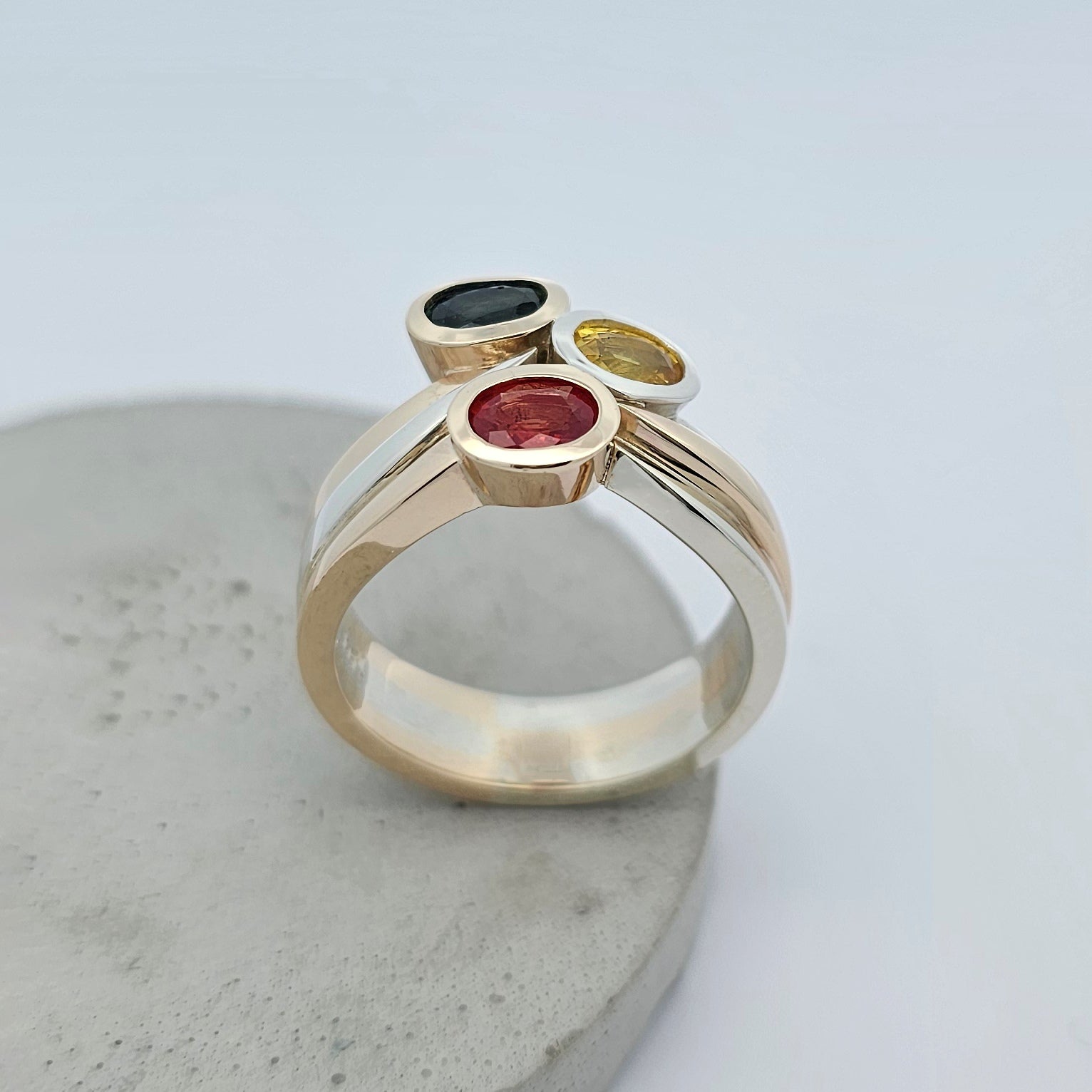 sapphire ring; three stone sapphire ring; natural sapphire ring; orange sapphire ring; blue sapphire ring; yellow sapphire ring; sapphire dress ring; sapphire cocktail ring; white gold and yellow gold sapphire ring; two tone sapphire ring; easy wear sapphire ring; sapphire engagement ring; curved sapphire ring; handmade sapphire ring; sapphire wedding ring; unique sapphire ring; 45th wedding anniversary; 45th wedding anniversary ring; September birthstone; September birthstone ring; celebration ring