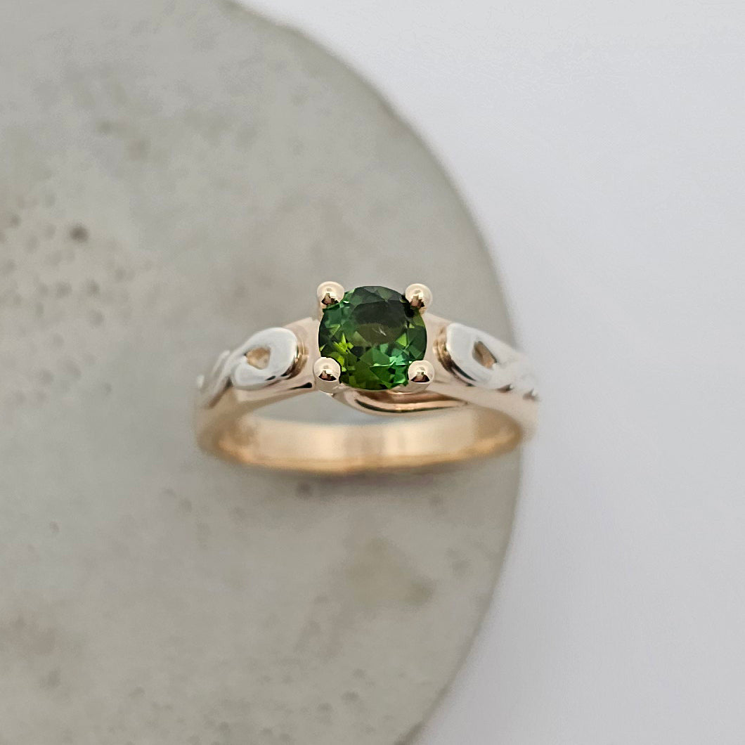 9ct yellow and white gold ladies coloured gemstone ring with a four claw set bright green round tourmaline and white gold shoulder details.