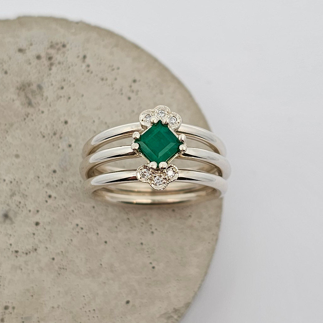 9ct white gold vintage inspired ladies dress ring featuring a claw set square emerald and bead set white diamonds with three bands of white gold.
