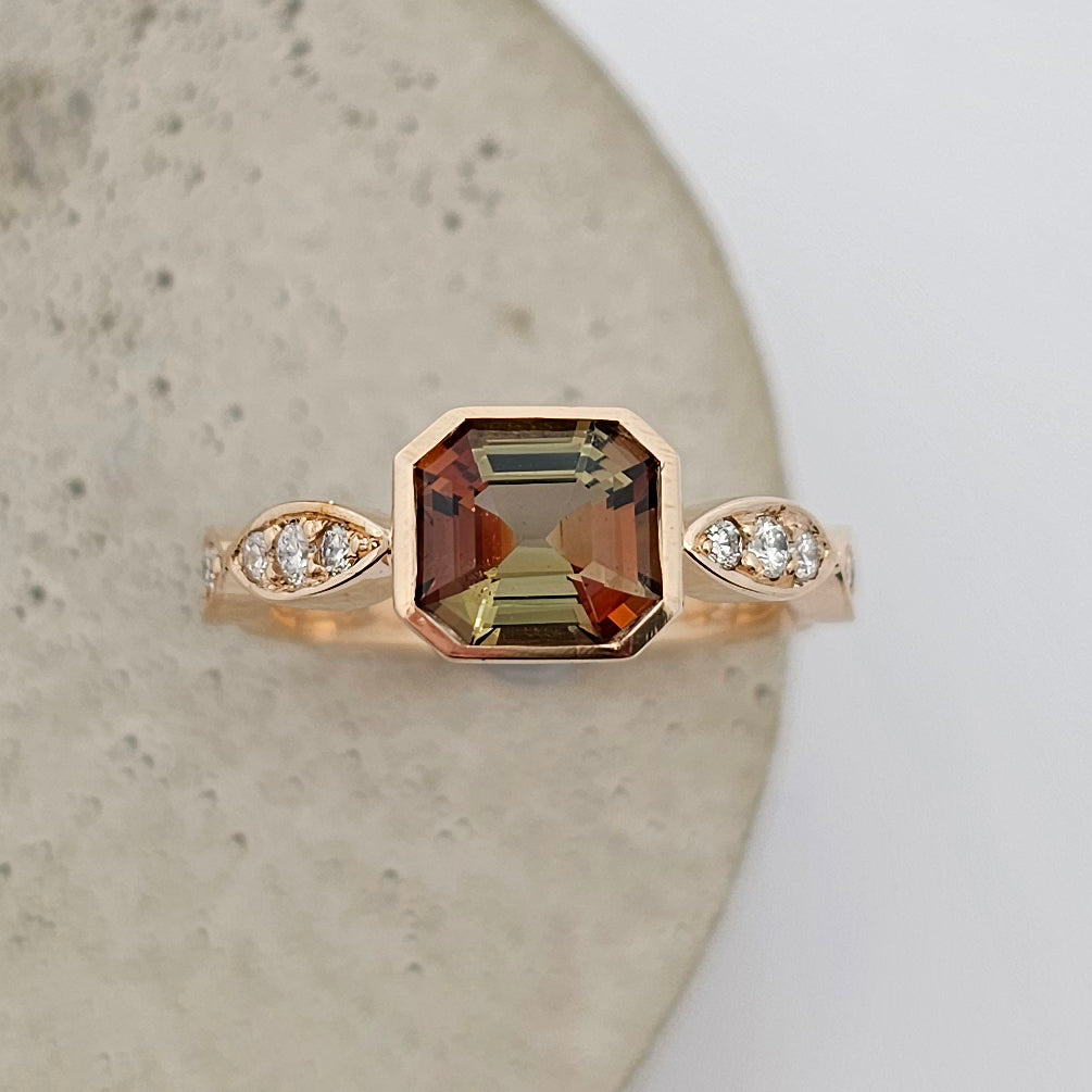9ct yellow gold ladies coloured gemstone ring with one full rub set emerald cut andalusite and marquise shaped diamond set shoulders.