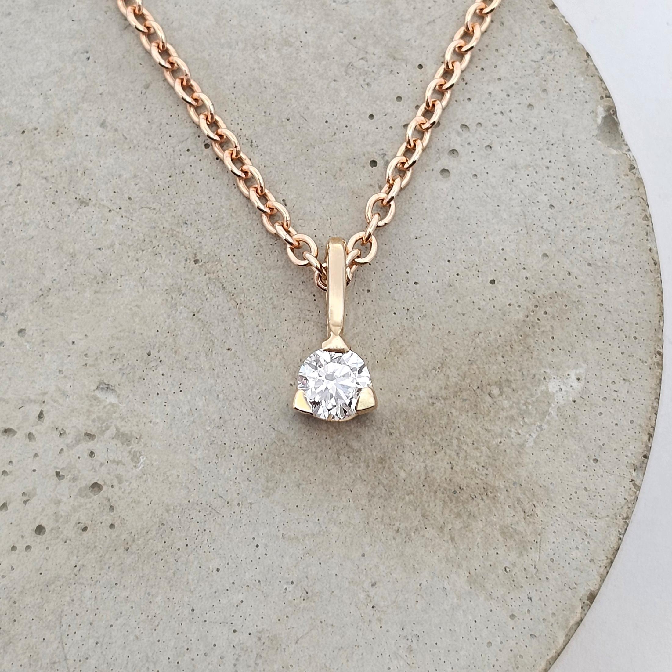 Petite diamond pendant featuring a very small round diamond in a classic open setting, designed for subtle sparkle and everyday wear.