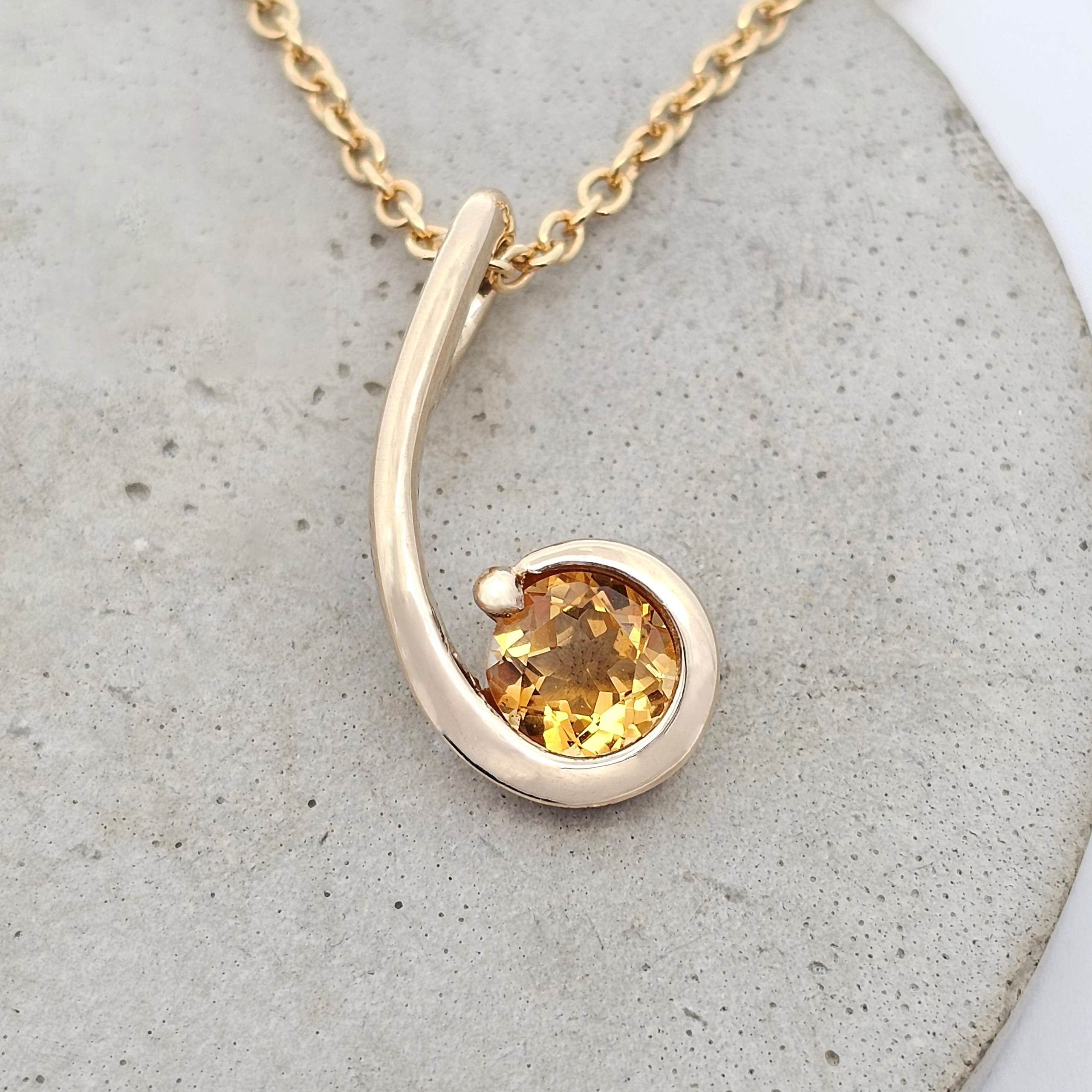 Yellow gold pendant featuring a golden citrine set within a flowing kōwhai-inspired curl.